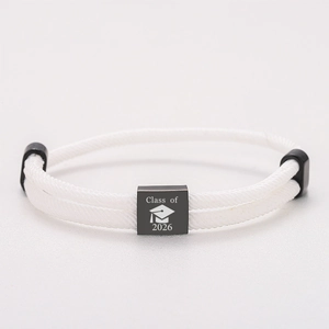 Detailansicht des Abschlussanhängers 2026 am verstellbaren weißen geflochtenen Armband