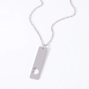Macro shot of stainless steel rectangular pendant with heart cutout on silver cable chain