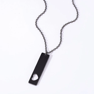 Close-up of black rectangular pendant necklace with heart cutout in stainless steel