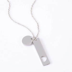 Detail of stainless steel necklace featuring round tag and hollow heart pendant charms