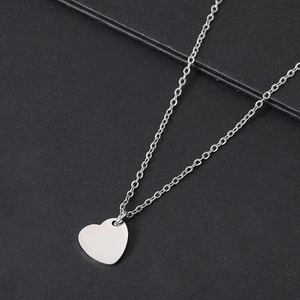 Close-up of heart-shaped stainless steel pendant with polished silver mirror finish