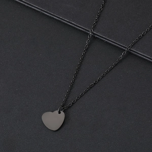 Macro shot of minimalist matte black heart pendant on a matching fine O-chain necklace