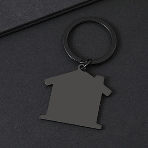 Detailed view of matte black house-shaped stainless steel keychain on textured background