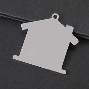 Macro shot of house-shaped stainless steel pendant with silver mirror finish and top hole