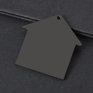Close-up of a house-shaped black stainless steel DIY pendant with a smooth mirror finish