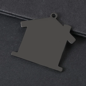 Macro detail of a house-shaped black stainless steel pendant with matte finish and top hole