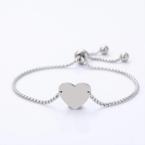 Detail of adjustable heart charm box chain bracelet with bolo clasp in polished steel