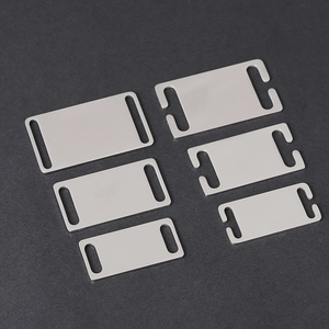 Detailed view of six stainless steel curved blank pet tags in different sizes and slots