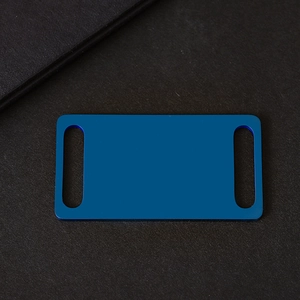 Macro shot of rectangular blue matte anodized aluminum pet ID tag with dual side slots