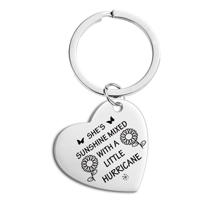 Macro shot of polished heart keychain with engraved inspirational quote and sunflower