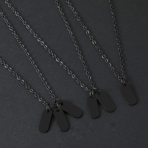 Macro shot of matte black stainless steel dog tag pendants on oval link chains