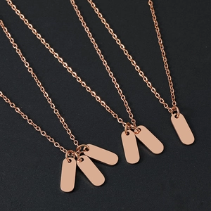 Rose gold stainless steel oval pendant necklaces on black textured background