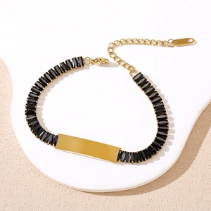 Détail du bracelet en acier doré avec zircons noirs et plaque personnalisable polie