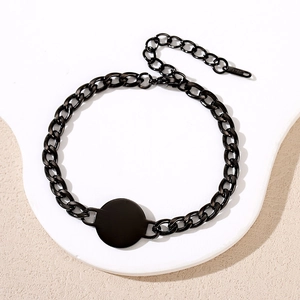 Matte black stainless steel Cuban chain bracelet with circular charm and logo tag