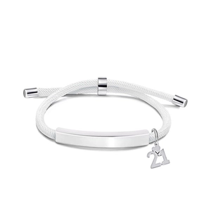 Macro shot of white woven bracelet featuring silver curved bar and number 21 heart charm