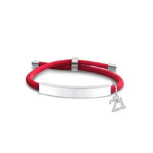 Detail of red braided bracelet with silver metal tag and heart-shaped number 21 charm