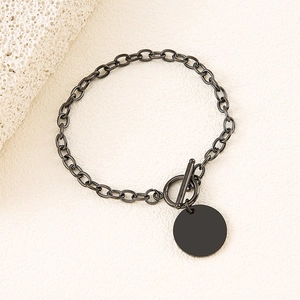 Detail of matte black stainless steel chain bracelet featuring an OT toggle clasp and round tag