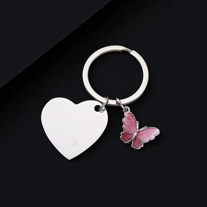 Detail of custom heart tag and pink glitter butterfly charm on stainless steel keychain