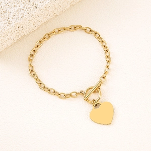 Detailed close-up of a polished gold heart pendant with OT toggle clasp on a link chain