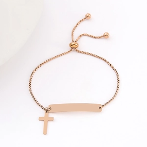 Macro shot of rose gold stainless steel bar bracelet with cross charm and slider closure
