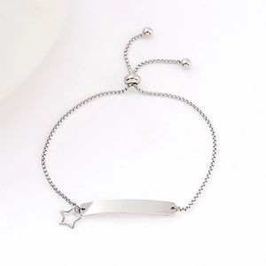 Detailed macro view of adjustable box chain bracelet with silver metal ID tag and star charm