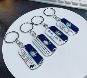 Close-up of four metal keychains with crown patterns and family emotional quotes