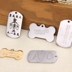 Customized stainless steel pet ID tags in various shapes like bone and shield on wood