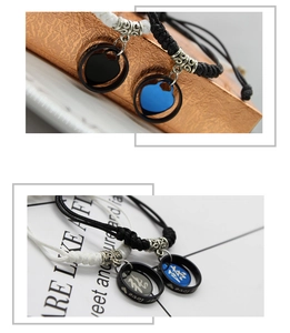 Close-up of couples braided bracelets with custom engraved ring and heart charms
