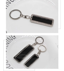 Detail of rectangular black metal keychains with crystal inlay and lobster clasp
