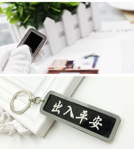 Detail of metal car keychain with rhinestones and lucky Chinese text engraving