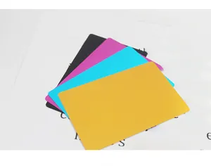 Close-up of four matte metal business cards in yellow, blue, pink, and black colors