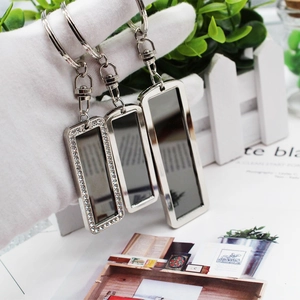 Mini black stainless steel rectangle keychains with rhinestones held in a professional setup