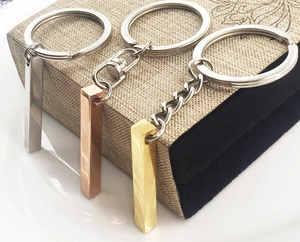 Detailed view of polished stainless steel cuboid keychains in silver gold and rose gold