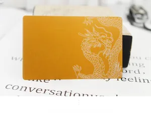 Detailed close-up of 0.2mm gold metal business card with white dragon engraving pattern