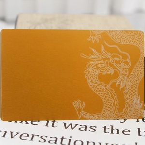 Golden brushed metal business card with laser-etched dragon design and rounded corners