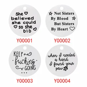Detailed macro view of four engraved stainless steel round charms with inspirational quotes