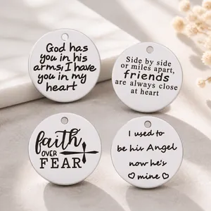 Detailed macro view of four round silver stainless steel pendants with engraved inspirational quotes