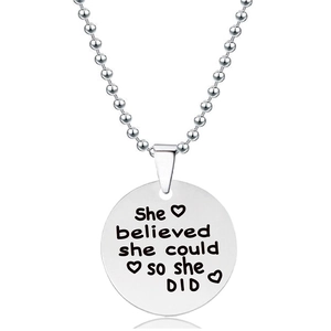 Detailopname van zilveren ronde hanger met gegraveerde quote en ballchain ketting