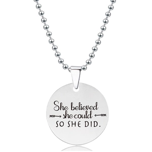 Detail van ronde hanger met gravure She Believed She Could So She Did en een bolletjesketting