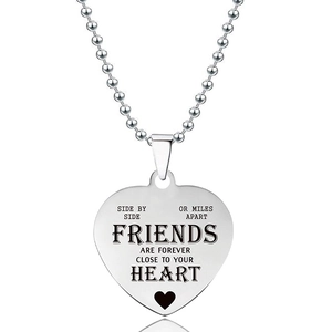 Detail van hartvormige hanger ketting met gegraveerde vriendschap tekst en bolletjesketting