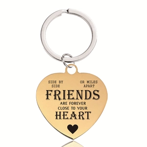 Close-up of gold heart keychain with Side by Side or Miles Apart friendship engraving