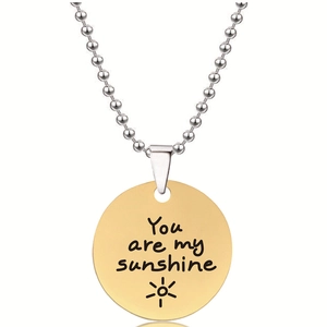 Detail van gouden ronde hanger met You Are My Sunshine gravure op zilveren kralenketting