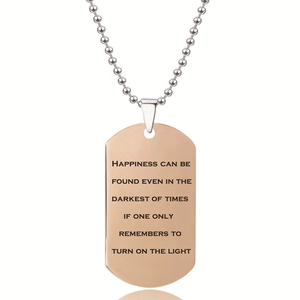 Detalle de colgante dog tag oro rosa con cita grabada con láser y cadena de bolas de acero