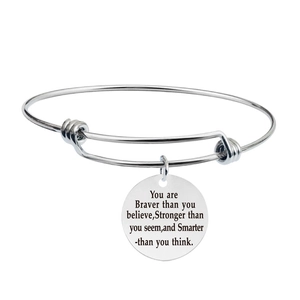 Close-up of expandable stainless steel bangle with engraved inspirational round pendant