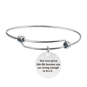 Detail of silver adjustable bracelet with an engraved inspirational quote charm