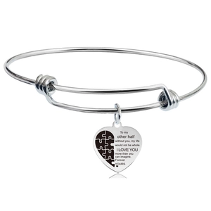 Poliertes silbernes Herzanhänger Armband mit Puzzle Design und Gravur auf weißem Hintergrund