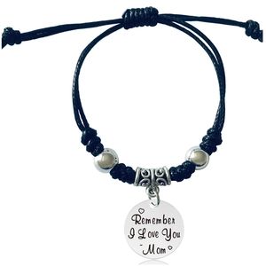Detailed view of woven black rope bracelet with silver beads and Mom charm engraving