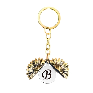 Détail du porte-clés médaillon tournesol doré avec lettre personnalisée gravée B