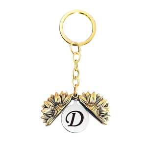 Détail d'un porte-clés tournesol doré à double couche avec la lettre D gravée