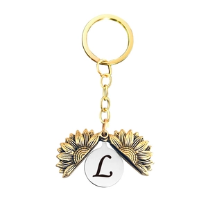 Détail d'un porte-clés tournesol doré avec une gravure de la lettre L à l'intérieur
